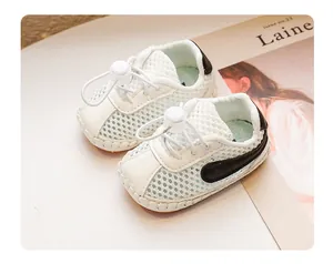 Nahaufnahme des atmungsaktiven Mesh-Gewebes bei weißen Baby-Lauflernschuhen in Weiß.