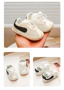 Makroansicht weißer Mesh-Babyschuhe mit weichen Sohlen und schwarzen Seitenakzenten