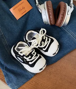 Detailed view of baby soft sole canvas sneakers in black and white with thick laces