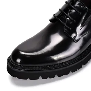 Close-up of black glossy patent leather Derby shoes with thick lug sole and lace-up