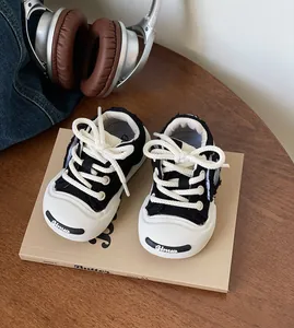 Detail of toddler black and white canvas walking shoes with chunky soles and thick laces.