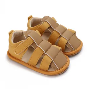 Detalle de sandalias amarillas de verano para bebé niño con tiras de velcro marrón suave