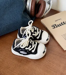 Close-up of black and white baby walking shoes with soft soles and thick laces