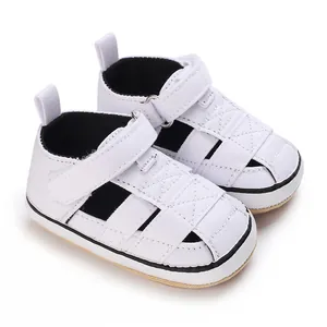 Close-up view of white canvas baby sneakers with soft non-slip rubber soles for infants.