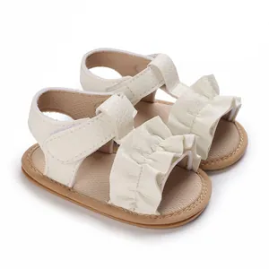 Vista macro de detalle de sandalias blancas para bebé con volantes elegantes y suelas blandas