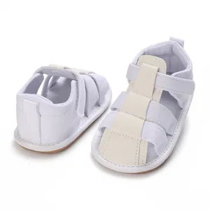 Detalle de sandalias blancas de lona transpirable para bebé con práctico cierre de velcro