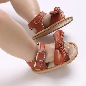 Detaillierte Makroaufnahme brauner Baby-Sandalen mit Schleife und weicher Sohle