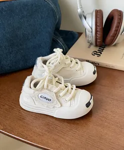 Close-up detail of cream canvas baby walking shoes featuring a soft rubber sole and GINUO logo