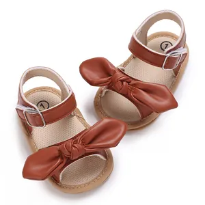 Detailansicht von braunen Baby-Sandalen mit einer großen dekorativen Lederschleife