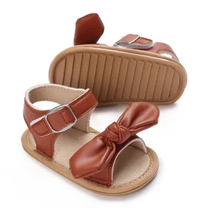 Detailaufnahme brauner Babysandalen für Mädchen mit großer Schleife und weicher Sohle