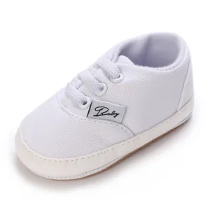 Détail de chaussure de marche bébé blanche avec semelle souple et étiquette Baby