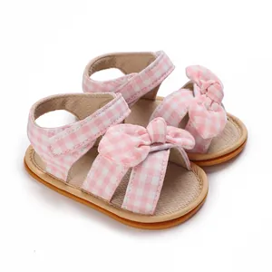 Detailed macro view of pink checkered baby girl sandals featuring a cute bow decoration
