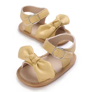 Detailaufnahme von gelben Babysandalen mit großer Schleife und weicher PU-Sohle
