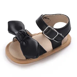 Detailansicht einer schwarzen Baby-Sandalen mit Schleife und weicher Gehsohle.