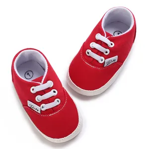 Vue détaillée de baskets en toile rouge pour bébé avec semelles et lacets blancs