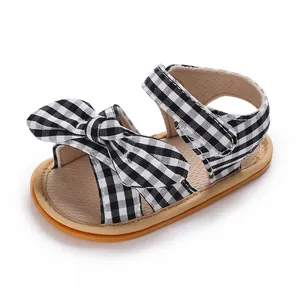 Close-up detail of black and white gingham baby girls sandals with a decorative bow