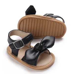 Detailaufnahme von süßen Baby-Mädchen-Sandalen aus schwarzem PU-Leder mit Schleifen-Deko