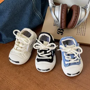 Three colors of stylish baby soft-sole canvas walking shoes displayed on a wooden surface