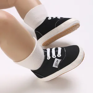 Gros plan de chaussures de bébé en toile noire avec semelles souples antidérapantes.