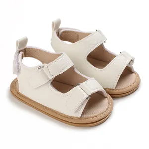Dettaglio di sandali beige per neonati con suole in silicone antiscivolo morbide 0-1 anno.