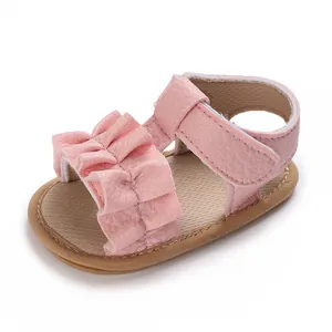Detalle de sandalias rosas con volantes para bebé niña con suelas de goma suave
