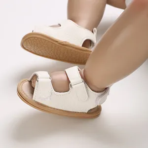 Close-up van witte baby sandalen met zachte zool en dubbele verstelbare klittenbanden.