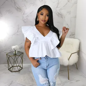Elegante weiße Bluse mit V-Ausschnitt und Rüschenärmeln, am Model in modernem Ambiente