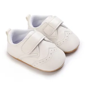 Close-up of white faux leather baby boy walking shoes with non-slip rubber soles
