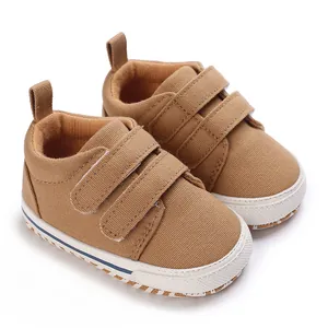 Detailed close-up view of brown canvas baby sneakers with double hook-and-loop straps.