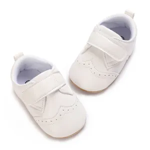 Detail view of white faux leather infant walking shoes with perforated wingtip design