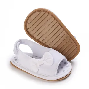Gedetailleerd overzicht van witte baby sandalen met strik, ademend mesh en antislip zool
