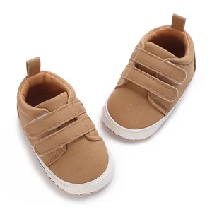 Close-up top view of brown canvas baby sneakers featuring double hook-and-loop straps
