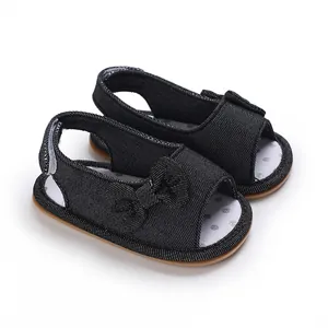 Nahaufnahme von schwarzen Baby-Sandalen mit Schleife und weicher Sohle