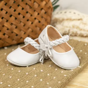 Detailansicht der weißen Baby Mary Jane Schuhe mit geflochtenem Bogenband und weichem Leder.