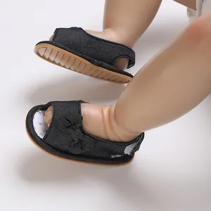 Gedetailleerd overzicht van ademende zwarte mesh babysandalen met een leuke strik