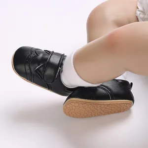 Close-up of black faux leather baby boy walker shoes with textured anti-slip rubber sole.