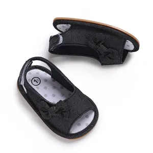 Detailansicht der schwarzen Baby-Sandalen mit Schleife und weicher Punkt-Innensohle