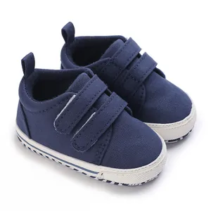 Macro view of dark blue canvas baby sneakers with double Velcro straps