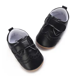 Top view of black leather baby walking shoes with brogue detailing and velcro straps