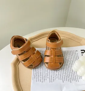 Gros plan de sandales romaines marron pour fille avec semelle souple et bande velcro