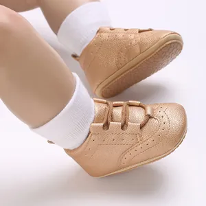 Close-up of stylish golden faux leather baby walking shoes with non-slip soft soles