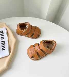 Détail de sandales romaines en cuir marron pour petites filles avec semelles souples et velcro