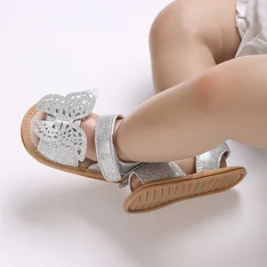 Close-up of baby girl silver glitter sandals with butterfly detail for pre-walkers.