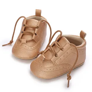 Detailed view of bronze faux leather baby shoes with decorative perforated patterns