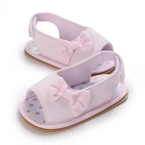 Detailansicht von rosa Babysandalen mit süßer Schleife und weichem, atmungsaktivem Stoff.
