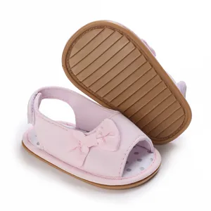 Detail van roze baby sandalen met strik, antislip zachte zool en stippen