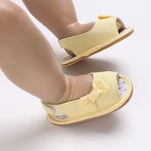 Detailansicht gelbe Babysandalen mit Schleife, atmungsaktivem Mesh und weicher Sohle.