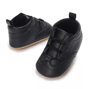 Macro view of black baby soft sole sneakers featuring textured faux leather and laces