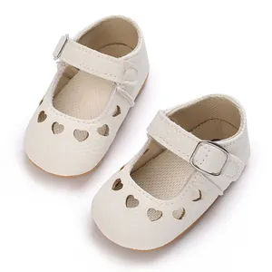 Close-up detail view of off-white baby Mary Jane shoes with hollow heart cutout patterns