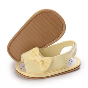 Detail van gele babysandalen met strik, zachte antislipzool en ademend mesh-materiaal